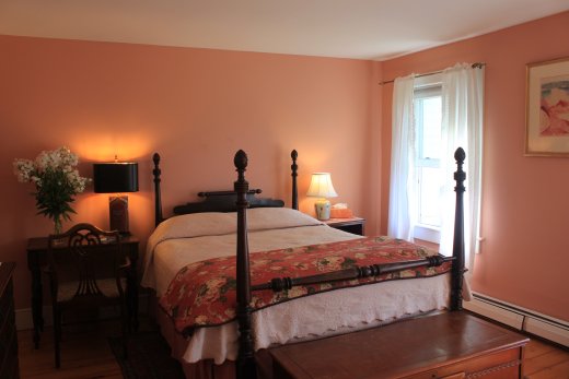 brecia colored room with four postered bed and reading lamps
